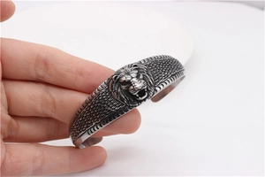 Close-up of vintage lion head cuff bracelet with detailed scales and engraved antique finish