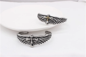 Detailed view of vintage steel feather bracelets featuring eagle wings and cross motifs
