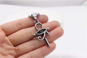 Detail of silver Ankh cross pendant with Eye of Horus and black gemstone on a chain