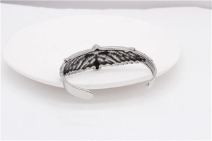 Macro detail of vintage silver eagle cuff bracelet showing intricate feather textures