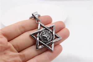 Macro detail of gothic hexagram skull pendant with vintage flame textures on steel