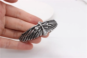 Macro shot of retro steel bracelet featuring eagle wings and 3D cross pattern