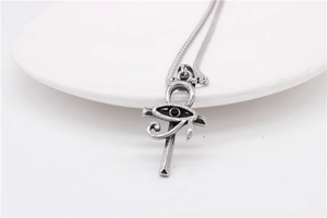Detail view of silver Eye of Horus and Ankh cross pendant with black gemstone inlay