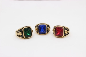 Detail of vintage skull rings featuring red, blue, and green rectangular gemstones