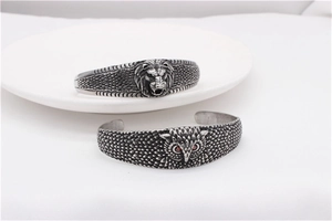 Detail of vintage lion and owl stainless steel open bracelets with red eye stones