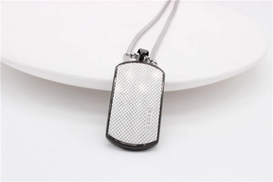 Detail of men's rectangle dog tag necklace with grid texture and five small white crystals