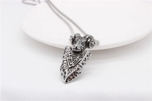 Macro view of vintage silver ram head pendant with Valknut symbol on steel chain