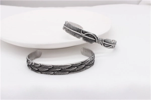 Detailed close-up of retro silver feather steel bracelets with oxidized vintage textures