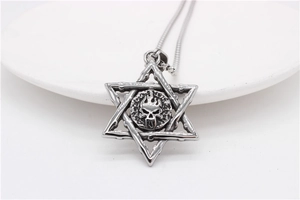 Macro shot of antique silver hexagram skull pendant with flame motif on steel chain
