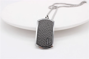 Detail of silver steel dog tag necklace with hammered texture and four small crystals