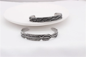 Close-up of vintage oxidized feather patterns on retro titanium steel bangles