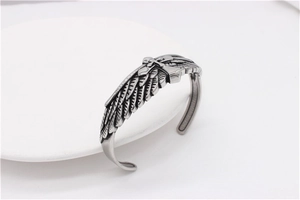 Macro view of vintage eagle wings and cross texture on the steel open cuff bracelet