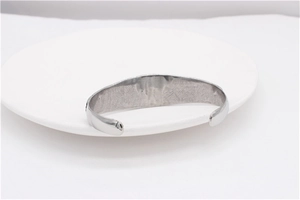 Detail of silver steel open cuff bracelet with inner brushed texture and polished finish