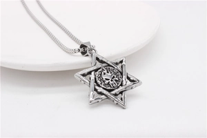 Macro shot of silver gothic hexagram pendant with skull and flame details on a chain