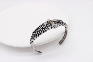 Detail of vintage eagle feather cuff bracelet with golden cross inlay on steel