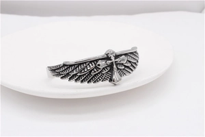 Macro shot of retro eagle wings and cross details on vintage steel cuff bracelet