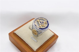 Macro detail of silver and gold Masonic ring with blue enamel and G compass symbol