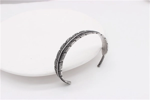 Close-up of retro feather carving details on vintage stainless steel men's cuff bracelet