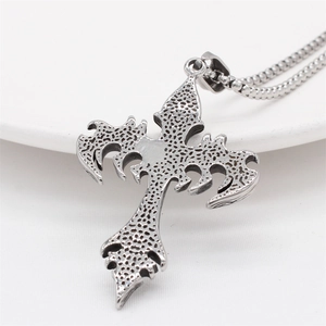 Gothic cross necklace with bat-wing motifs and etched textures on a steel pendant