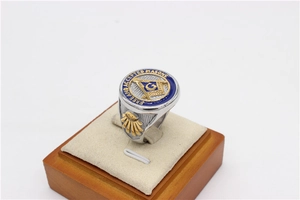 Macro shot of silver Masonic ring with blue enamel and G compass square emblem details