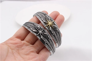 Detailed close-up of retro feather embossed cuff bracelet with octagonal star motif
