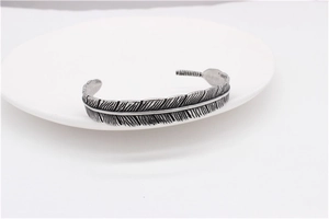 Detailed close-up showing the vintage silver feather texture of this steel bracelet