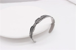 Detailed close-up of retro feather textured open bangle in antique silver finish steel