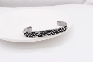 Detail shot of vintage silver-tone wide cuff bracelet with intricate Celtic braid texture
