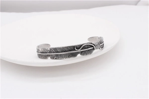 Macro shot of vintage feather cuff bangle with detailed blackened silver engraving