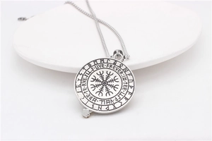 Macro shot of Viking Vegvisir compass pendant with runes on stainless steel surface