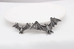 Detailed view of Gothic bat wing pendants in vintage silver finish for DIY jewelry