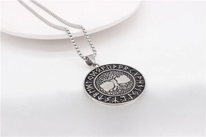 Close-up of vintage Viking Tree of Life pendant with Nordic runes and steel box chain