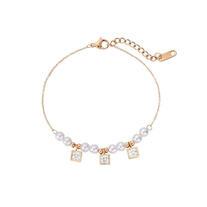 Détail du bracelet en acier inoxydable or rose avec perles et breloques en zircon