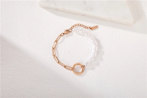 Detailed close-up of rose gold paperclip chain and white pearl bracelet with clasp
