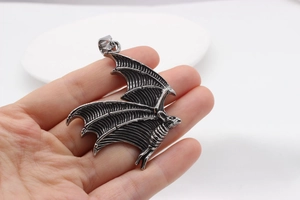 Close-up of gothic bat wing pendant in titanium steel with detailed wing texture