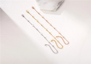 Detailed view of three heart-shaped minimalist bracelets in silver, gold, and rose gold