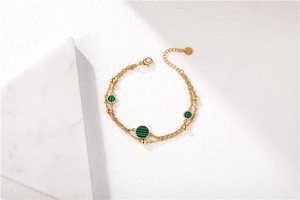 Detail of double-layer gold chain bracelet with peacock blue malachite round inserts