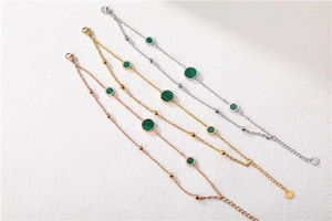 Detailed view of three layered chains with malachite beads in gold, silver and rose gold