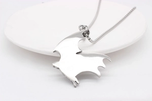 Detailed close-up of gothic bat wing pendant on a sleek stainless steel box chain