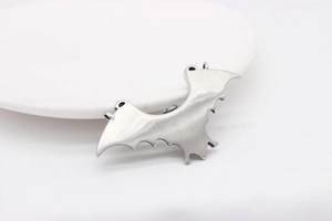 Close-up of gothic bat wing pendant showing detailed brushed stainless steel finish