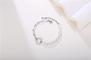 Detail of silver paperclip chain bracelet with irregular pearls and 18KGP metal tag