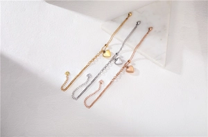 Set di tre braccialetti con ciondoli a cuore nelle finiture oro, argento e oro rosa