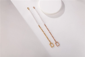 Détail de bracelets élégants en perles et chaîne dorée avec pendentifs rectangulaires