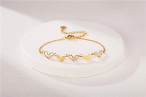 Detail of gold titanium steel heart bracelet with white mother of pearl inlays and adjustable chain