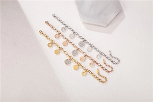 Vista macro detallada de las pulseras de cadena en oro y plata con dijes de Good Luck