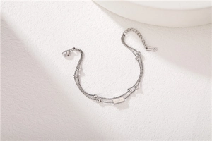 Detail of double-layer stainless steel bracelet with LUCKY plate and beaded chain