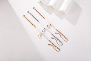 Detail view of gold, silver, and rose gold beaded bracelets with heart charms and pearls