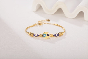 Detail of gold titanium steel bracelet with evil eye beads and snake chain structure