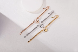 Detail showing gold silver and rose gold heart pendants on heavy link chain bracelets