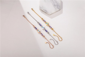 Detailed view of evil eye charms on three-piece stackable beaded chain bracelets